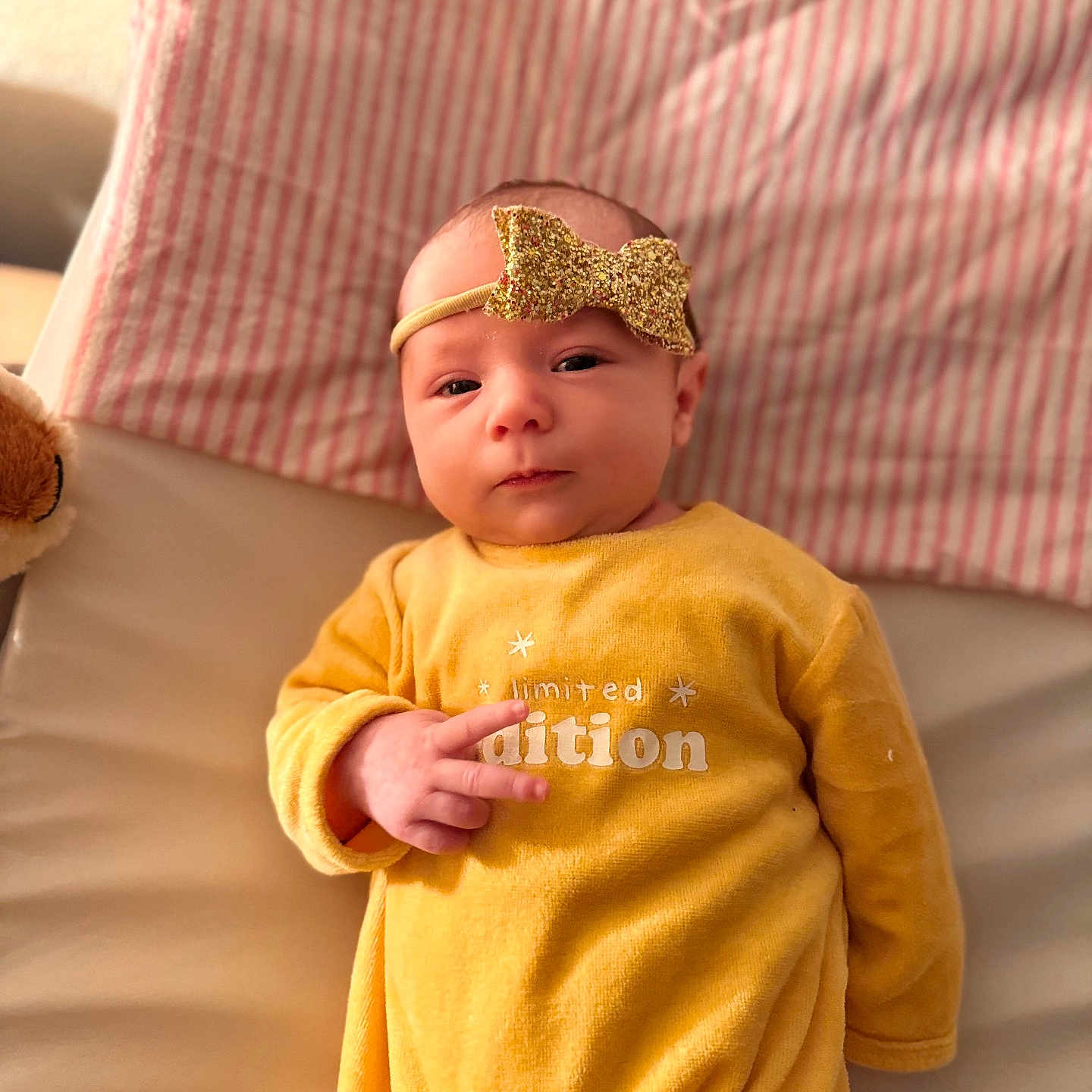 Abigaëlle participe au concours pour gagner de l'argent avec cette photo : adorable, baby, bow, child, clothing, cute, expression, face, hands, headband, indoors, infant, lying_down, newborn, peace_sign, portrait, sleepwear, soft_surface, striped_blanket, yellow_outfit