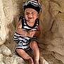 Nolhan a rejoint le concours — aidez-le/la à gagner de superbes lots ! baby, child, smile, striped_clothing, hat, pom_pom, sitting, blanket, fluffy, beige, happy, cute, infant, portrait, indoors, soft_texture, clothing, person, skin, headwear