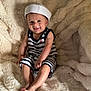 Nolhan a rejoint le concours — aidez-le/la à gagner de superbes lots ! baby, child, smile, sailor_hat, striped_clothing, sitting, fluffy_blanket, happy, cute, portrait, indoor, infant, barefoot, soft_texture, young_child, comfortable, headwear, person, cozy, light