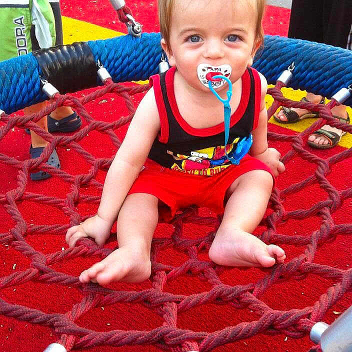 Adir joined the competition — help win amazing prizes! barefoot, black_tank_top, blue_eyes, child, colorful, fun, happy, kids, legs, net, outdoor, pacifier, play, playground, pony_tail, red_shorts, rope_swing, ropes, summer, toddler