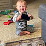baby_gate, boy, carpet, casual, child, clothing, cute, floor, furniture, happy, home, indoor, person, playtime, room, sitting, smartphone, smiling, toddler, toy