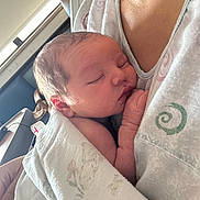 Dawson is registered to the contest to win money with this photo: newborn, baby, sleeping, blanket, closeup, person, skin, arm, hand, face, indoors, natural_light, comfort, cuddle, tenderness, soft_texture, parent, hospital, peaceful, rest