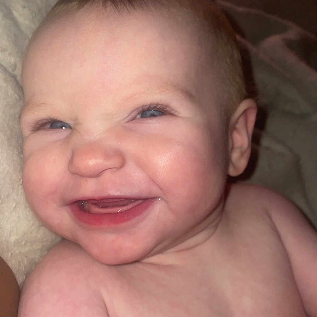 Adilynn is registered to the contest to win money with this photo: baby, baby_skin, bare_shoulders, blanket, cheek, child, closeup, cute, expression, face, hands, happy, indoors, infant, joy, person, portrait, skin, smile, young