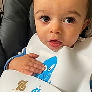 Noam participe au concours pour gagner de l'argent avec cette photo : child, baby, face, hand, bib, high_chair, curious, closeup, indoor, cute, young, eyelashes, skin, clothing, expression, sitting, person, infant, head, portrait