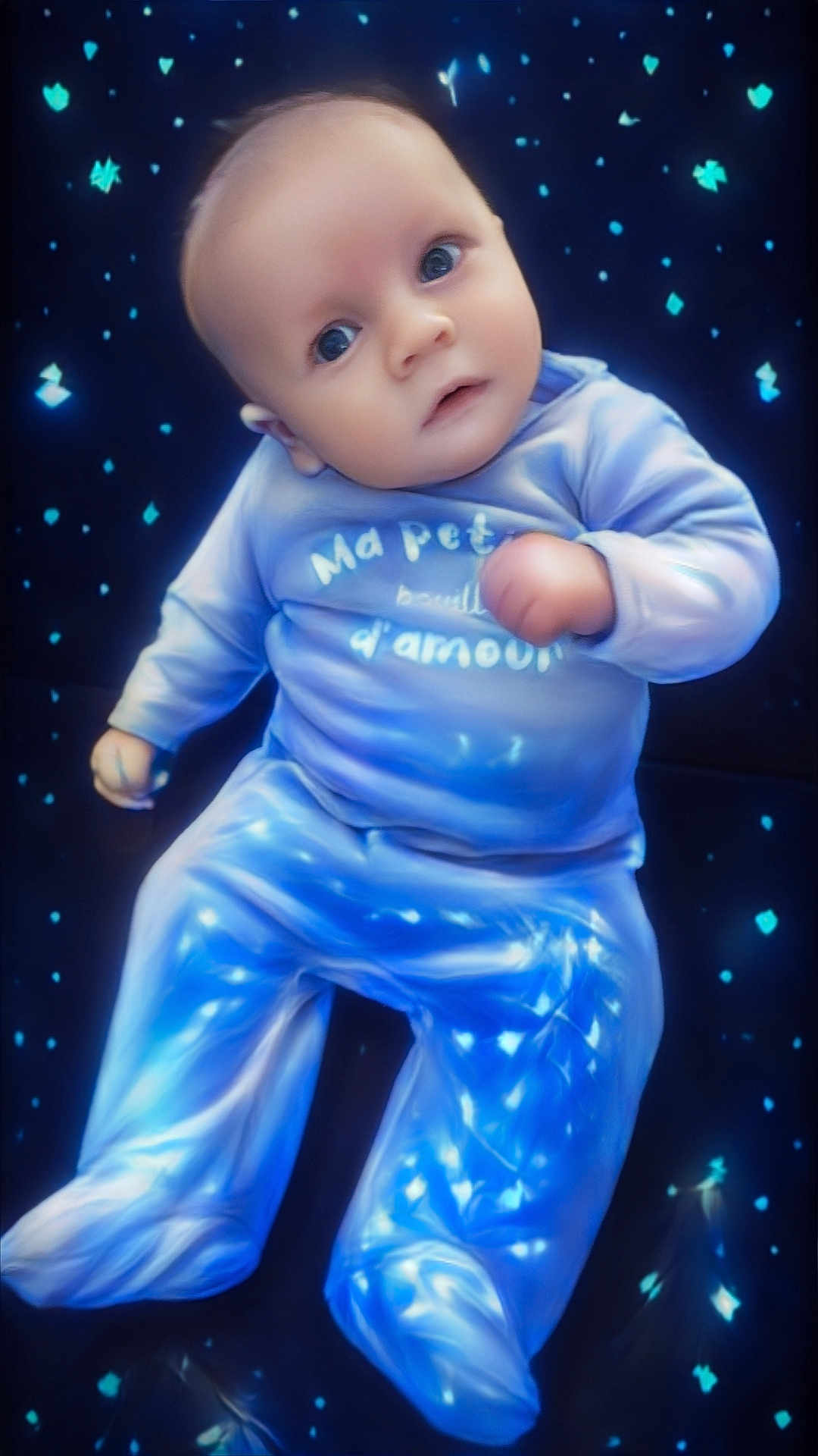 Kaylan a rejoint le concours — aidez-le/la à gagner de superbes lots ! baby, infant, child, face, eyes, onesie, pajamas, blue, stars, background, lying_down, portrait, cute, chubby_cheeks, soft_light, smile, hand, close_up, baby_clothes, studio_lighting