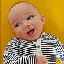 Hadj participe au concours pour gagner de l'argent avec cette photo : baby, smiling, striped_clothing, infant, happy, portrait, cute, child, face, eyes, mouth, hand, yellow_background, casual, one_person, indoors, head, skin, young, cheerful