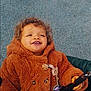 Zaina participe au concours pour gagner de l'argent avec cette photo : toddler, child, smiling, curly_hair, brown_coat, jacket, stroller, hand, outdoor, happy, cute, face, portrait, baby_accessory, pacifier, button, clothing, person, footwear, blue_shoes