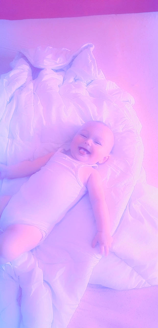 Layna a rejoint le concours — aidez-le/la à gagner de superbes lots ! baby, bedtime, child, comfort, electric_blue, finger, fun, happy, human_leg, linens, magenta, person, petal, pink, purple, room, sitting, smile, textile, toddler