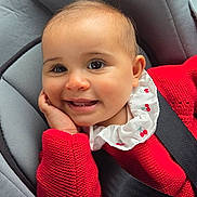 Elyana a rejoint le concours — aidez-le/la à gagner de superbes lots ! baby, baby_girl, car_seat, child, child_seat, closeup, clothing, cute, face, hand, happy, head, indoor, infant, person, portrait, red_sweater, seatbelt, smiling, young_child