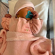 Inaya participe au concours pour gagner de l'argent avec cette photo : baby, blanket, child, cozy, crib, cute, face, hand, hat, indoors, infant, newborn, pacifier, peaceful, pink_clothing, resting, sleeping, soft_texture, toddler, wrapped