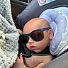Astonn is registered to the contest to win money with this photo: baby, infant, child, sunglasses, car_seat, car, vehicle, blanket, portrait, face, sleepy, serious_expression, sitting,  안전, seatbelt, indoor, close_up, cute, travel, photography