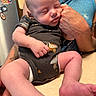 newborn, baby, infant, sleeping, portrait, person, adult, holding, arms, onesie, truck_pattern, barefoot, face, closed_eyes, indoors, kitchen, countertop, refrigerator, tattoo, family