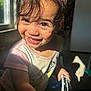 toddler, child, smiling, indoor, sunlight, window, face, happy, person, short_hair, clothing, holding, toy, shadow, bright, skin, closeup, expression, young_child, casual