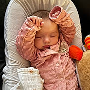 Kiara a rejoint le concours — aidez-le/la à gagner de superbes lots ! baby, sleeping, pink_outfit, plush_toy, blanket, cushion, cozy, infant, soft_texture, peaceful, child, resting, indoors, cute, young_child, face, hands, comfort, bedtime, toddler