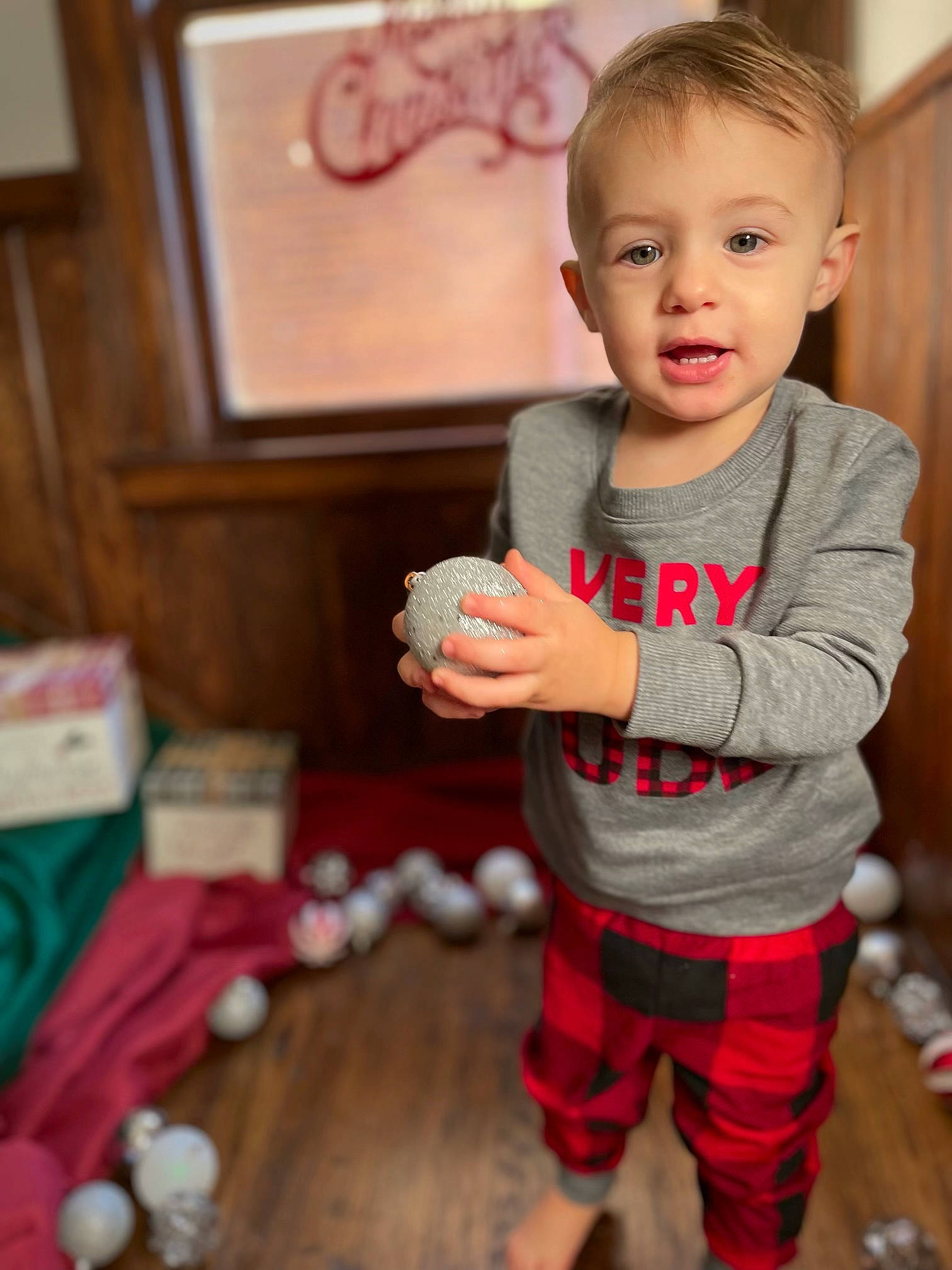 Remington is registered to the contest to win money with this photo: baby, baby_toddler_clothing, cheek, child, christmas, event, eye, face, flooring, fun, happy, holiday, person, picture_frame, pink, room, sitting, sleeve, smile, toddler