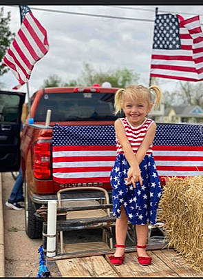 Mava is registered to the contest to win money with this photo: automotive_exterior, automotive_lighting, bumper, car, cloud, electric_blue, event, family_car, flag, flag_day_usa, flag_of_the_united_states, holiday, joy, luxury_vehicle, motor_vehicle, person, recreation, sky, toddler, trunk