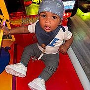 Chōzyn is registered to the contest to win money with this photo: toddler, child, arcade, game_machine, bandana, white_sneakers, red_surface, curious, indoor, flooring, pacifier, bracelet, clothing, short_sleeve, pants, toy, play, entertainment, colorful, person