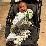 Chōzyn is registered to the contest to win money with this photo: baby, smiling, sneakers, stroller, blanket, floor, tile, clothing, infant, footwear, person, indoor, happy, cute, child, sitting, portrait, head, face, playful