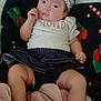 baby, infant, headband, bow, shirt, diapers, blanket, floor, clothing, cute, child, person, indoor, soft_texture, pink, black, wooden_floor, relaxed, expression, portrait