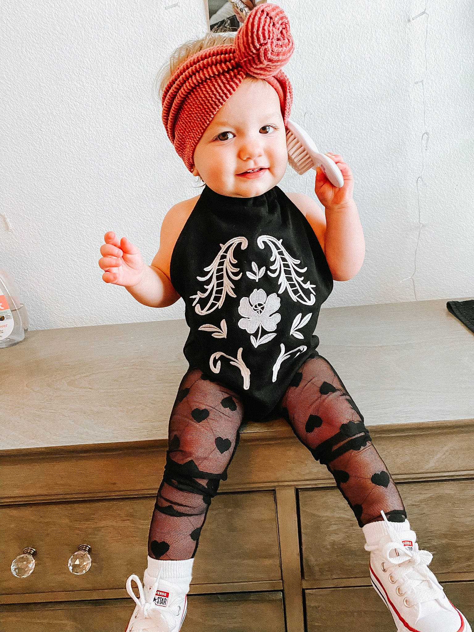 Kinlee is registered to the contest to win money with this photo: arm, baby, beanie, child, clothing, footwear, head, headgear, headwear, human_leg, joint, knee, leg, leggings, person, pink, skin, sleeve, sock, thigh