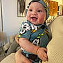 Messiah is registered to the contest to win money with this photo: apparel, baby, cabinet, child, clothing, cute, decor, face, furniture, hand, happy, headwear, holding, home, indoor, infant, living_room, person, portrait, smiling