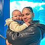 Messiah joined the competition — help win amazing prizes! baby, woman, hug, smile, jacket, hoodie, indoor, aquarium, blue, face, person, child, love, affection, warmth, casual_clothing, portrait, closeup, holding, happy