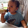Arlo joined the competition — help win amazing prizes! toddler, child, high_chair, bottle, drinking, blue_shirt, shark_graphic, indoor, window, daylight, curtains, face, person, baby, feeding, smile, short_hair, hand, table, home