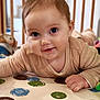 baby, infant, child, smile, closeup, portrait, crawling, playmat, toy, doll, crib, wooden_bars, big_eyes, cute, indoor, soft_clothing, hand, mouth, polka_dot, floor_mat