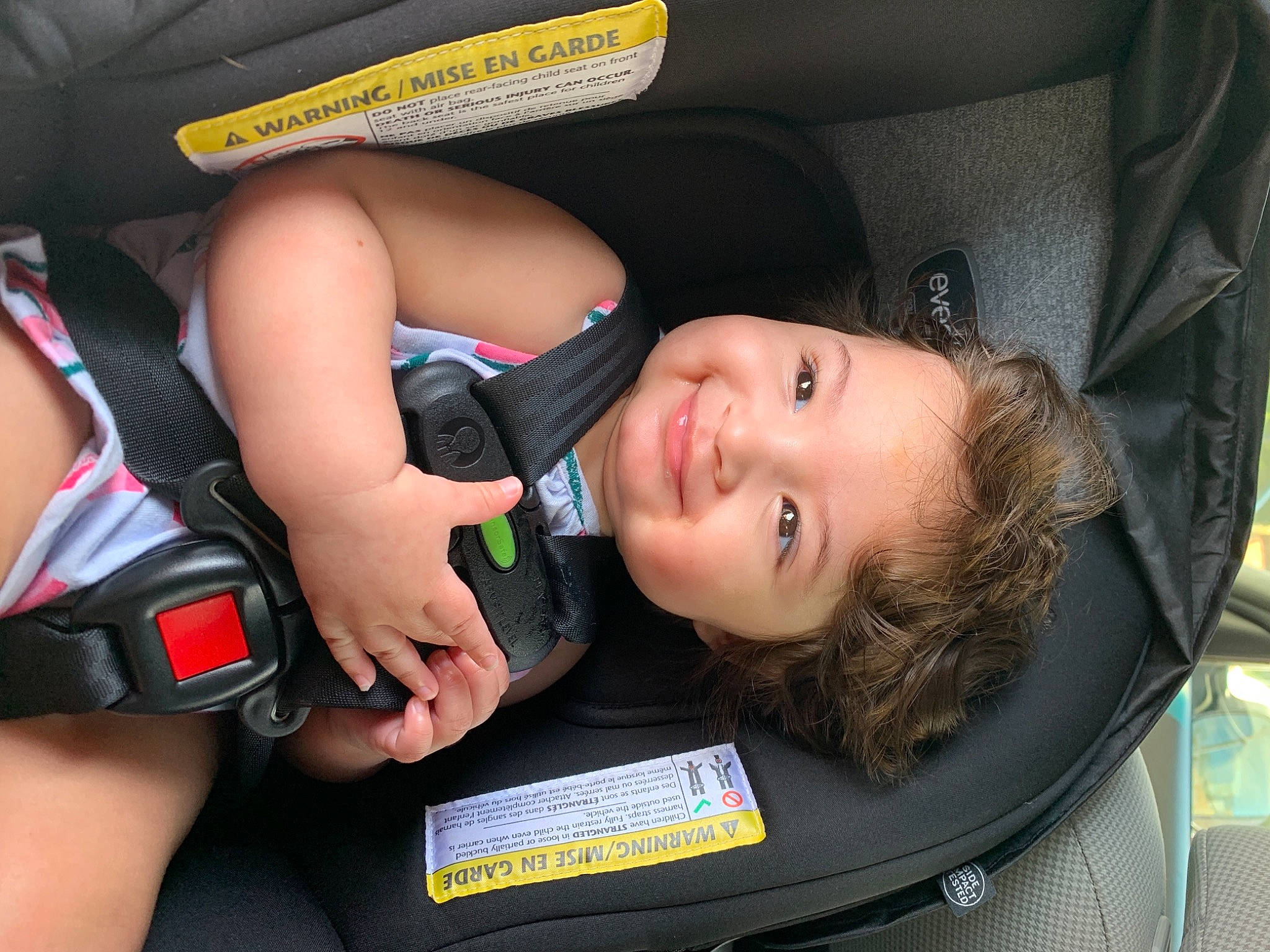 Michele is registered to the contest to win money with this photo: auto_part, baby_carriage, baby_products, car_seat, car_seat_cover, chest, child, comfort, elbow, fun, joy, knee, mouth, nail, person, seat_belt, shorts, smile, thigh, thumb