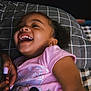 child, girl, laughing, smiling, pink_shirt, minnie_mouse, pillow, checkered_pattern, curly_hair, earrings, bed, hand, nail_polish, close_up, indoor, happy, joy, portrait, family, candid