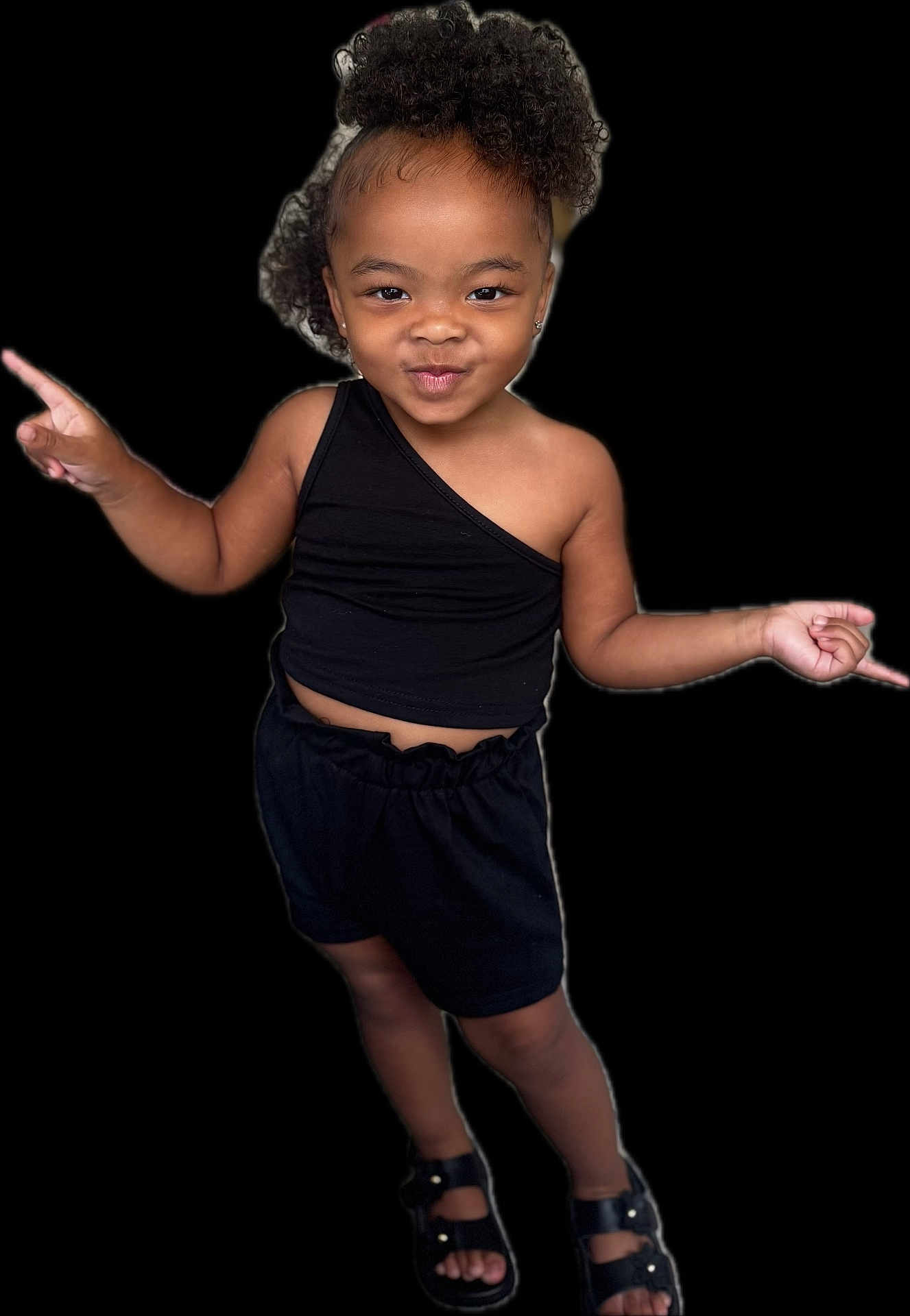 Nuri is registered to the contest to win money with this photo: child, girl, smile, posing, black_top, black_shorts, sandals, curly_hair, earrings, confident, standing, fashion, cute, playful, black_background, portrait, happy, person, youth, stylish