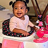 toddler, child, baby_walker, toy, minnie_mouse, pink, smiling, indoor, person, happy, hair_puffs, seat, clothing, cute, playful, young_child, table, furniture, face, portrait