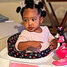 toddler, baby_walker, child, toy, minnie_mouse, pink, curly_hair, pigtails, indoors, table, furniture, clothing, person, cute, expression, looking_away, seat, playful, young_child, home