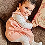 baby, infant, child, sofa, cushion, dress, tights, sitting, cute, portrait, smile, dark_hair, big_eyes, indoors, fabric, pattern, texture, hand, cozy, seat