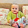 Baby joined the competition — help win amazing prizes! baby, infant, smiling, sitting, couch, sofa, pillow, knit_sweater, green_sweater, buttons, toy, stuffed_animal, zebra_toy, spiral_toy, bare_feet, big_eyes, portrait, living_room, upholstery, cushion