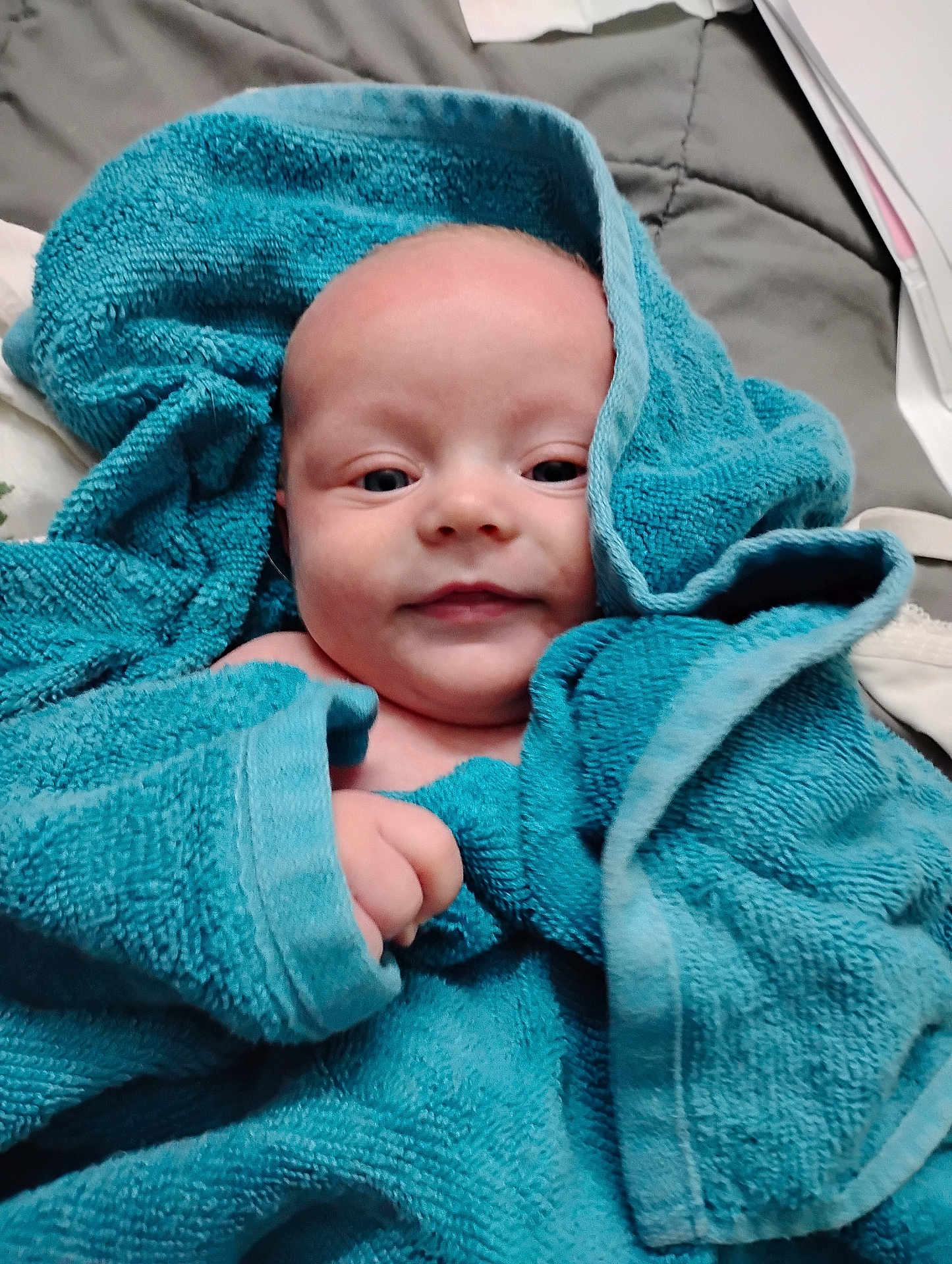 Kinnon joined the competition — help win amazing prizes! baby, towel, blue, smile, face, infant, wrapped, cozy, cute, skin, hand, portrait, newborn, child, blanket, soft, comfort, lying_down, indoors, expression