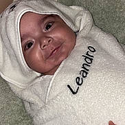 Léandro participe au concours pour gagner de l'argent avec cette photo : baby, towel, hooded_towel, smile, face, infant, wrapped, hand, embroidery, soft_texture, blanket, cozy, cute, child, indoors, person, skin, nail, fingernail, comfort