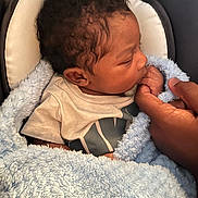 Zakari joined the competition — help win amazing prizes! baby, infant, blanket, blue_blanket, hand, adult_hand, curly_hair, sleeping, resting, clothing, toddler, closeup, cute, skin, person, soft_texture, comfort, love, family, indoor
