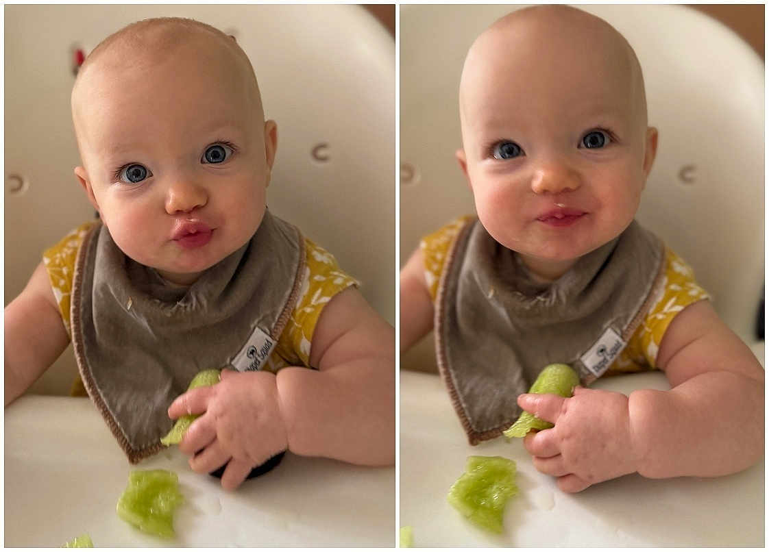 Emilia joined the competition — help win amazing prizes! baby, child, infant, blue_eyes, bib, food, green_food, high_chair, cute, smiling, playful, hands, face, table, eating, indoor, portrait, expression, closeup, person