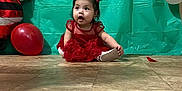 Melani is registered to the contest to win money with this photo: baby, balloons, celebration, child, curious_expression, cute, festive, floor, holiday, indoor, party_decoration, pigtails, plastic_backdrop, portrait, red_dress, santa_decoration, sitting, tile_floor, toddler, young_child