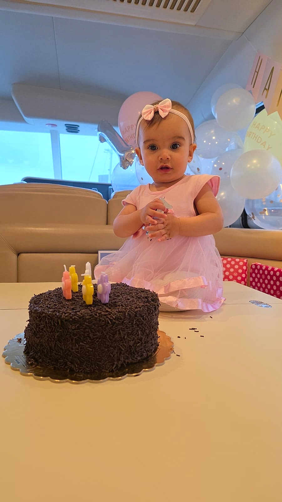Flore a rejoint le concours — aidez-le/la à gagner de superbes lots ! child, baby, birthday, cake, candles, pink_dress, bow, balloons, party, celebration, indoor, table, chocolate, sprinkles, face, person, happy, cute, smile, event