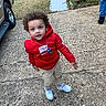 Jakarye joined the competition — help win amazing prizes! child, curly_hair, red_hoodie, beige_pants, white_sneakers, driveway, outdoor, grass, vehicle, person, jeans, black_shoes, sidewalk, curious, standing, casual_clothing, daylight, concrete, yard, candid