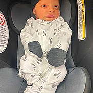 Jakarye joined the competition — help win amazing prizes! baby, infant, car_seat, clothing, sleeper, hat, face, person, newborn, child, seat, safety, black, white, pattern, cute, indoors, resting, small, wrapped