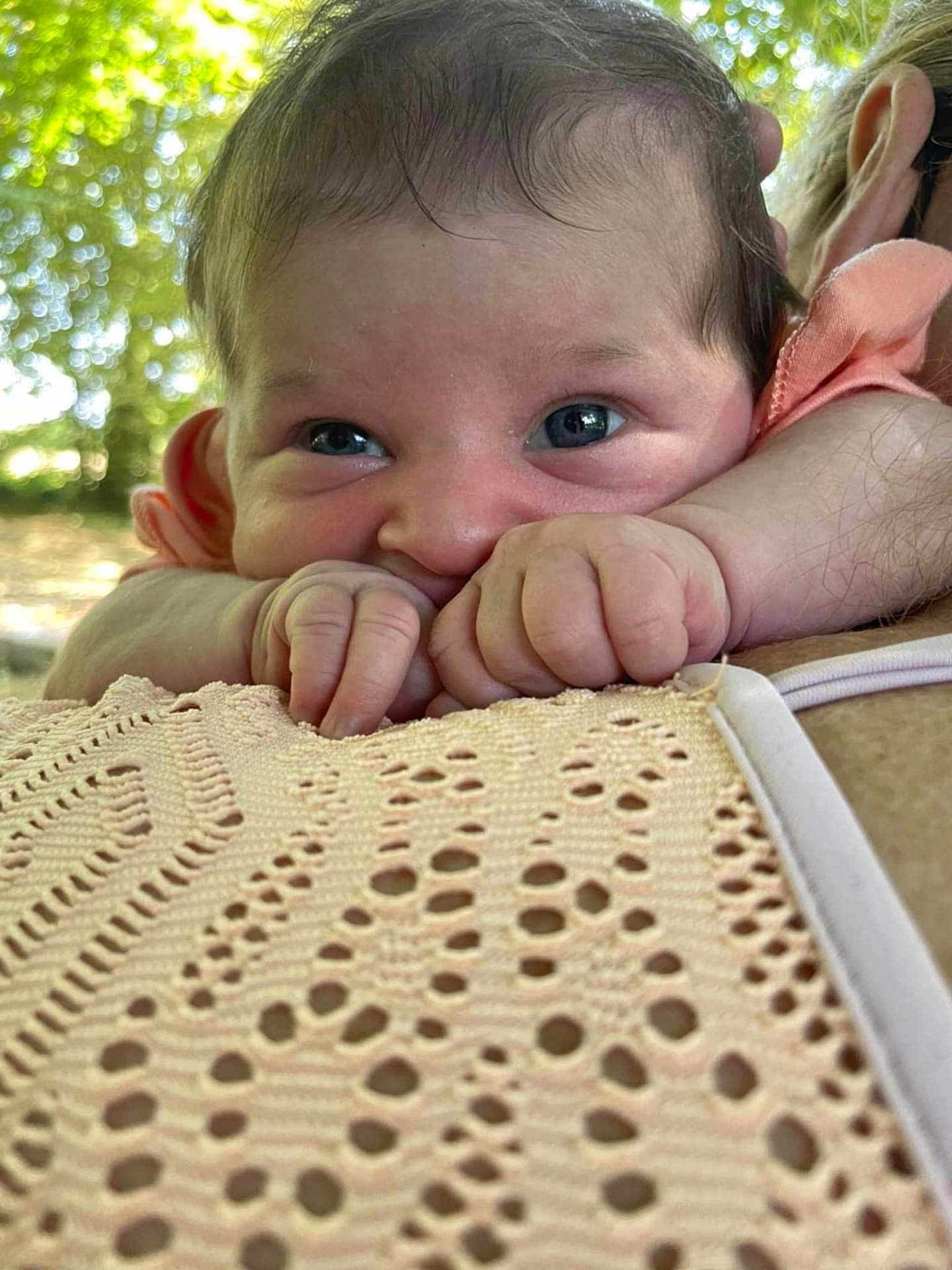 Louméa participe au concours pour gagner de l'argent avec cette photo : baby, infant, face, hands, person, skin, closeup, outdoor, nature, shoulder, holding, curious, expression, human, head, young, cute, portrait, daylight, resting