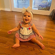 Emma is registered to the contest to win money with this photo: baby, child, smiling, headband, dress, sitting, floor, wooden_floor, indoor, happy, cute, arms, legs, girl, person, head, clothing, foot, home, window