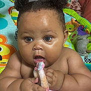 Deasia joined the competition — help win amazing prizes! baby, child, infant, portrait, sitting, wide_eyed, curly_hair, hair_buns, bare_shoulders, bath_time, blanket, plush_toy, pink_blanket, play_mat, colorful, indoor, bedroom, close_up, happy, text_overlay