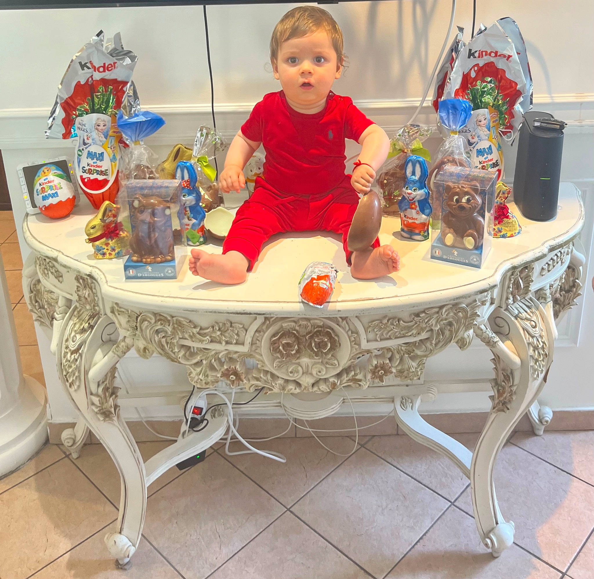Benjamin a rejoint le concours — aidez-le/la à gagner de superbes lots ! baby, baby_products, baby_toddler_clothing, coffee_table, flooring, furniture, hardwood, leisure, living_room, outdoor_furniture, person, porcelain, rectangle, room, shelf, sitting, surprise, table, tableware, toddler