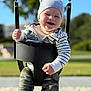 Mark is registered to the contest to win money with this photo: baby, child, smiling, swing, playground, outdoor, hat, beanie, hoodie, camouflage_pants, happy, infant, seat, sunny, daylight, grass, trees, park, person, portrait