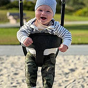 Mark joined the competition — help win amazing prizes! baby, child, swing, playground, hat, smile, happy, outdoor, park, sand, clothing, camo_pants, sock, person, daylight, fun, joy, infant, seat, chains