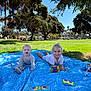 baby, blanket, blue_sky, child, crawling, daytime, girl, grass, happy, infant, nature, outdoor, park, person, play, shade, smile, sunlight, toy, tree